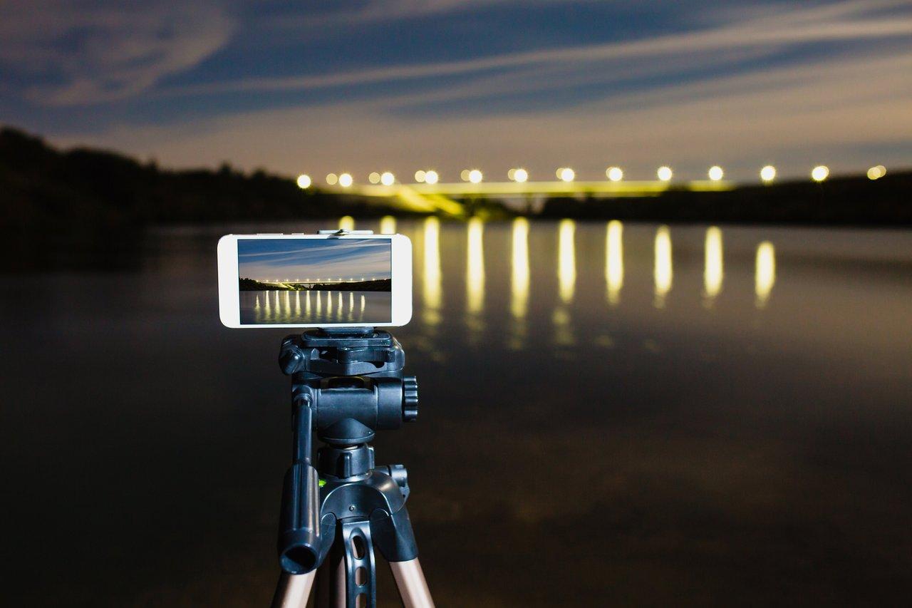 Configuration de smartphone pour la photographie professionnelle, avec appareil photo hybride en arrière-plan.