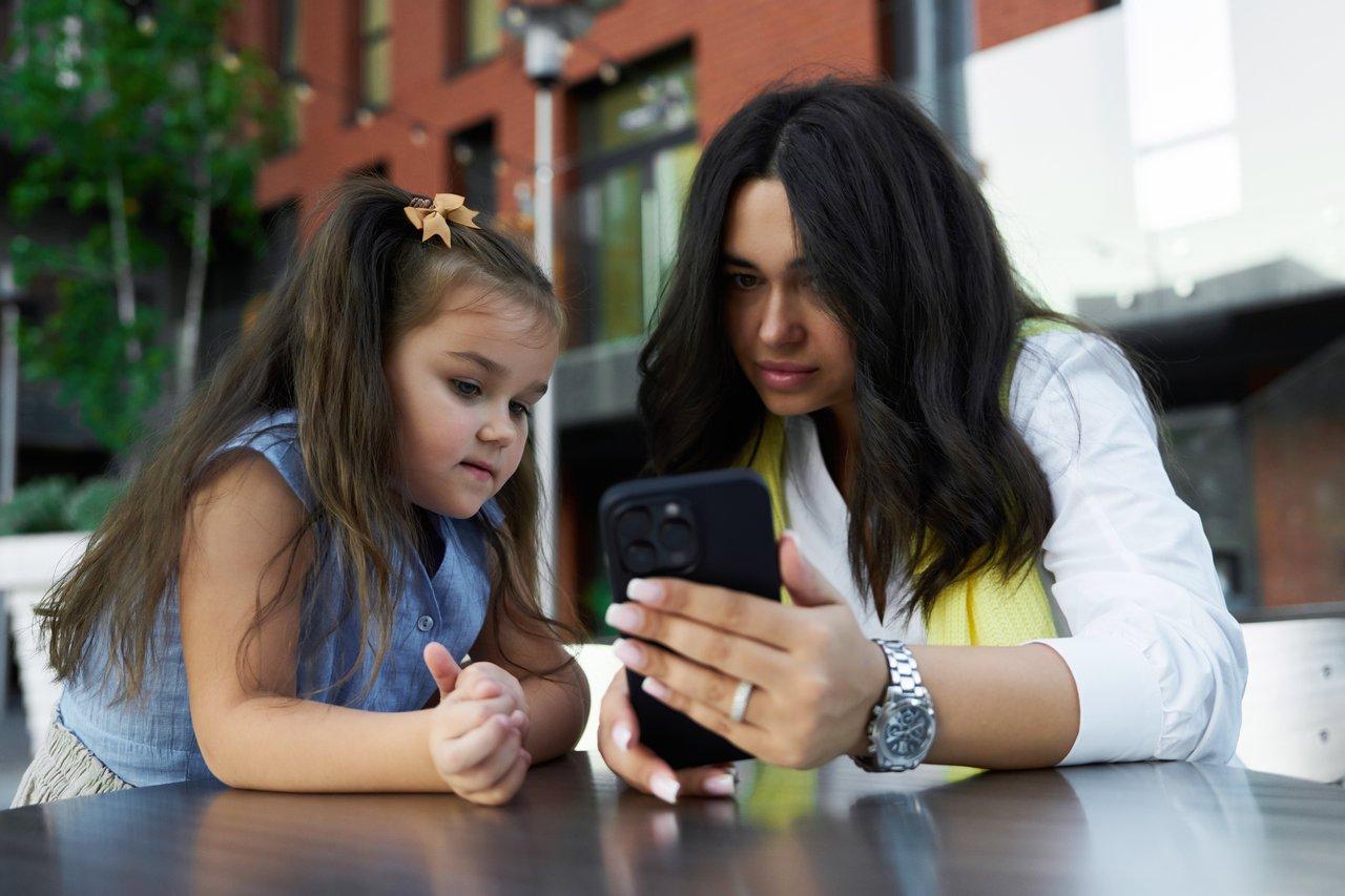 Contrôle parental sur smartphone : mère et fille profitent d'un moment en extérieur.
