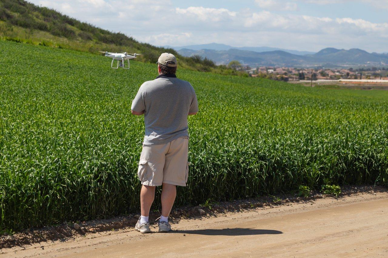 Drone agricole survolant un champ avec capteurs IoT et graphiques de données pour une agriculture durable.