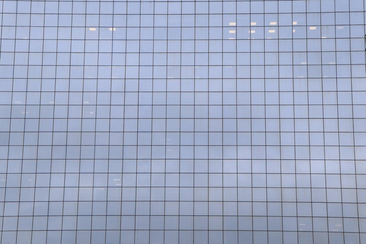 Façade en verre intelligente avec motif en grille, s'assombrissant automatiquement selon la lumière ambiante.