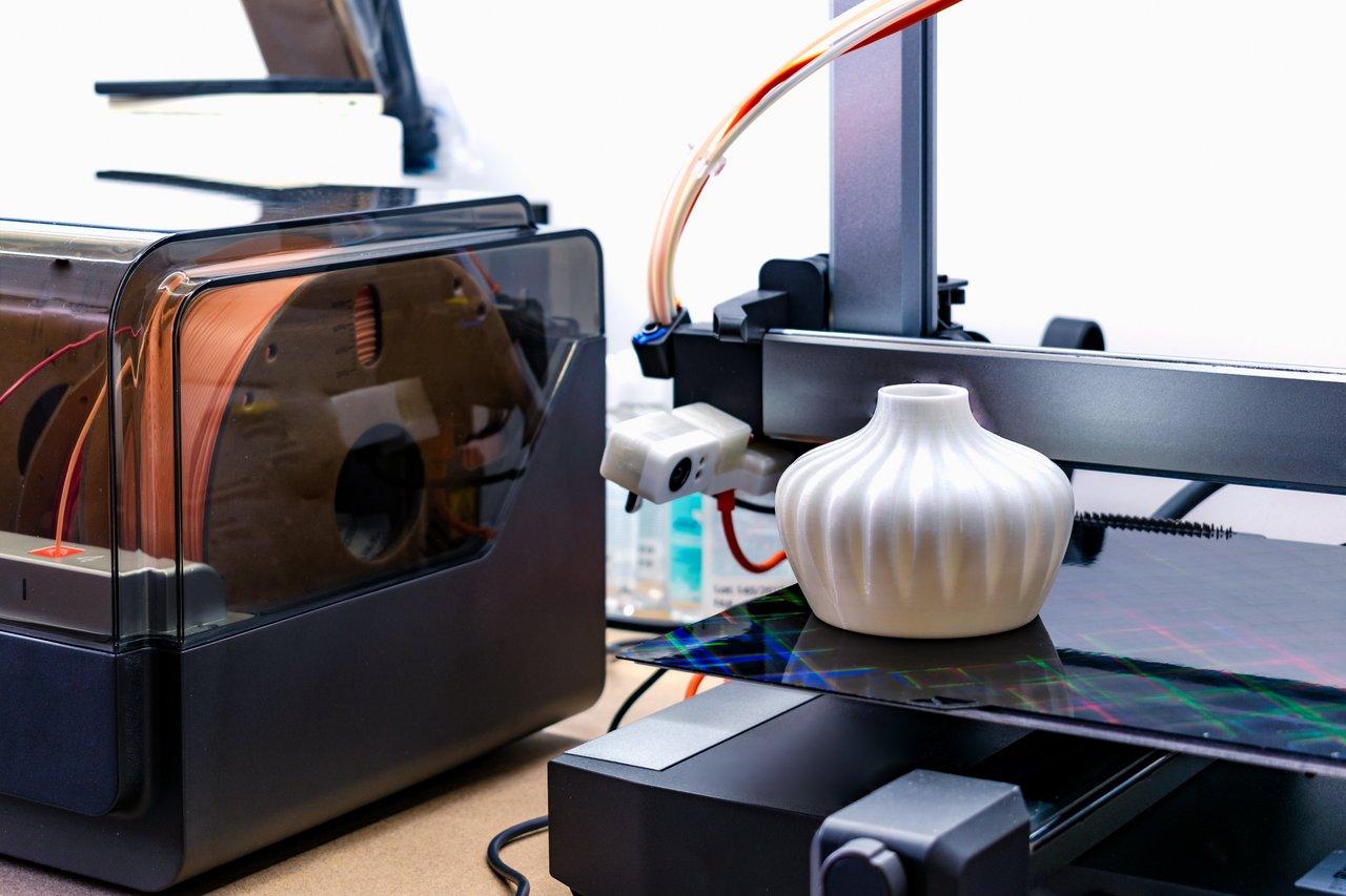 Imprimante 3D industrielle avec marquage CE, opérateur en équipement de protection dans un showroom.