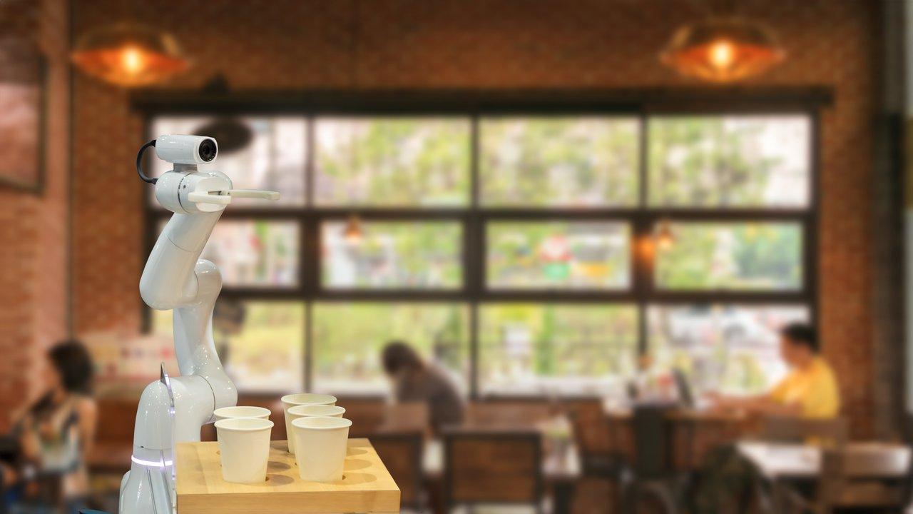 Un robot de cuisine automatisé en action dans un restaurant moderne illustrant l'innovation en foodtech 2025.