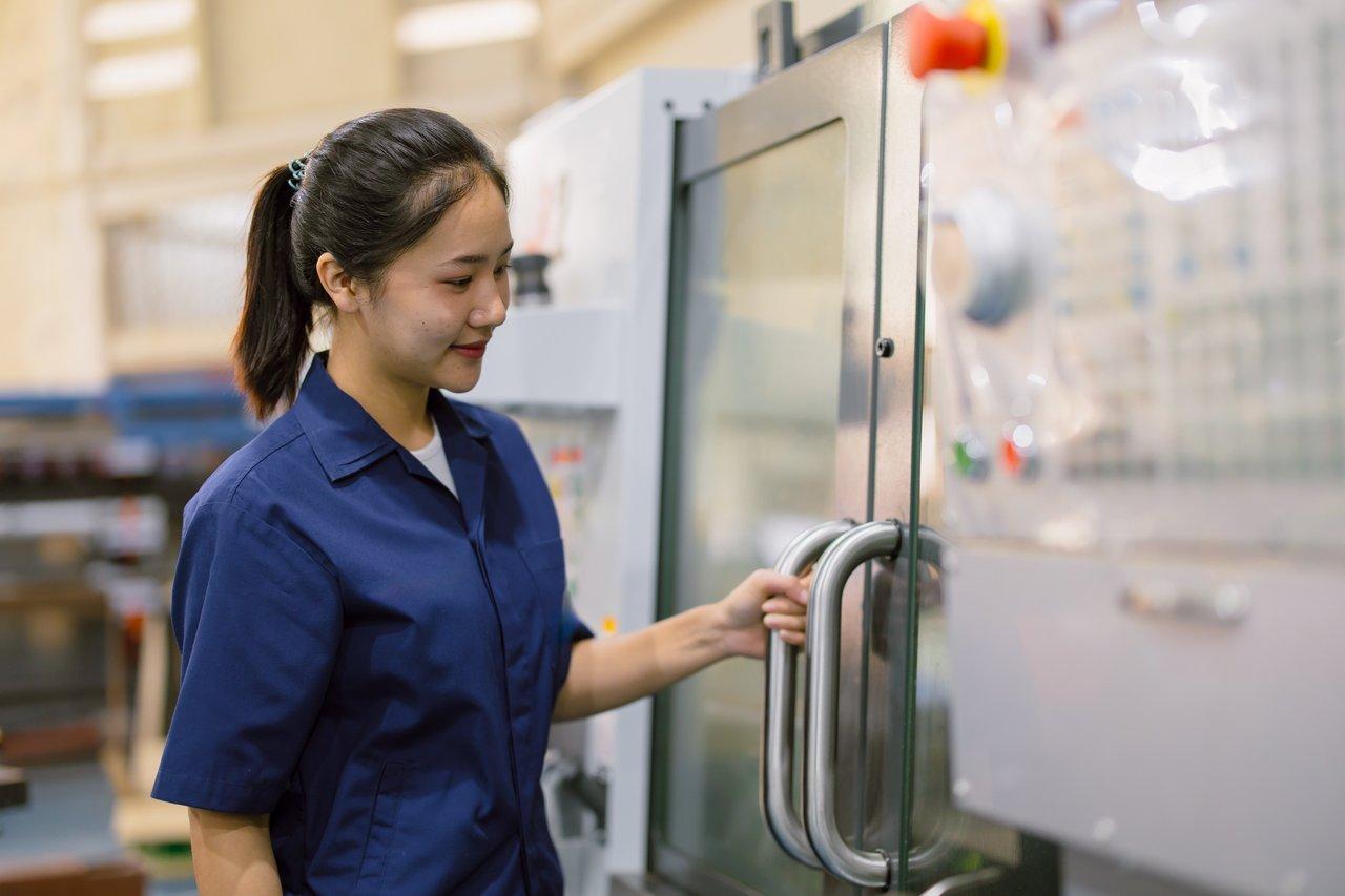 Un technicien effectue le post-traitement manuel d'une pièce imprimée en 3D pour un outillage industriel personnalisé.