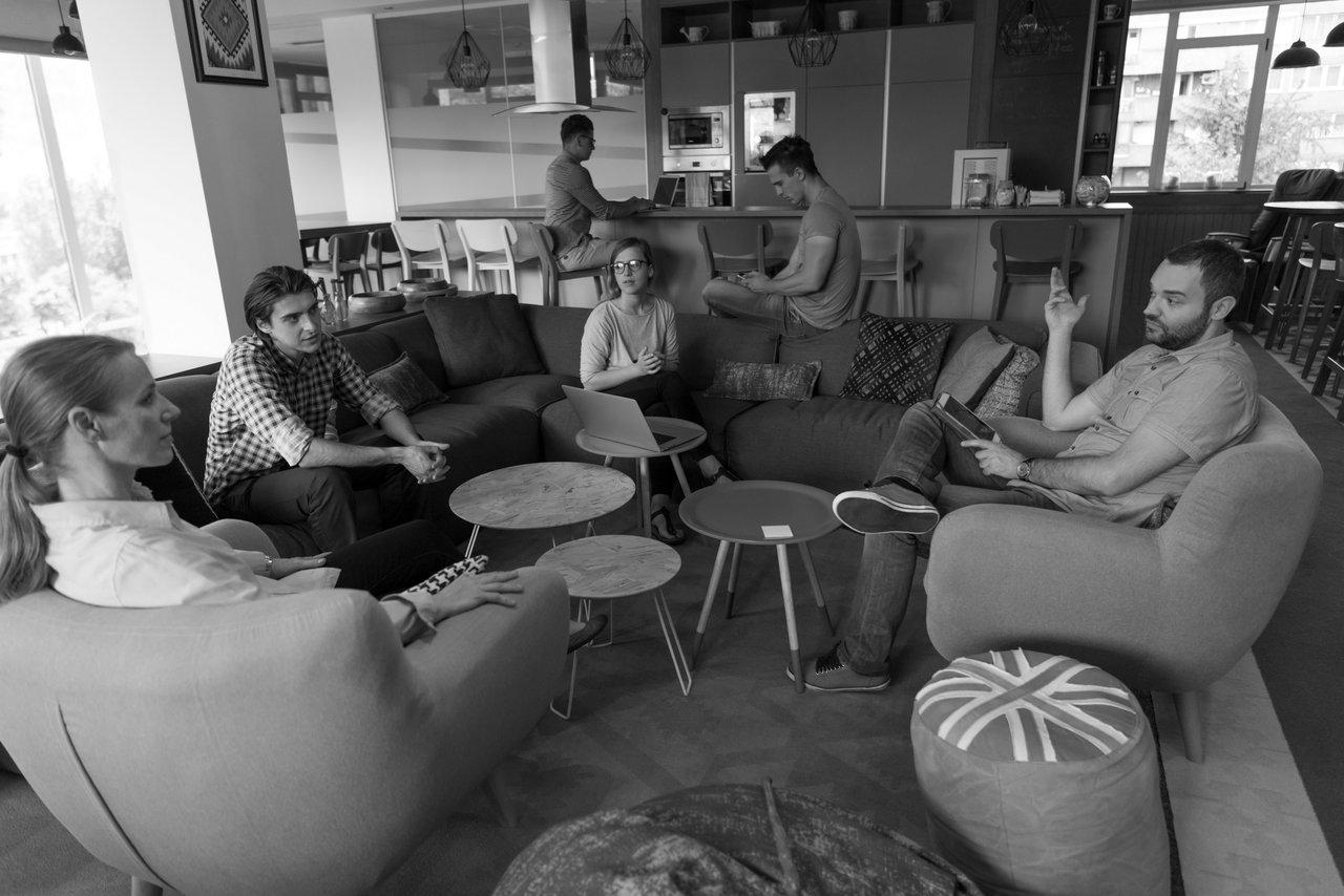 Une équipe deeptech en réunion de brainstorming, analysant prototypes technologiques et graphiques de marché.