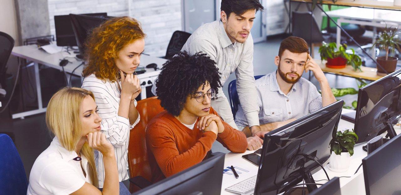 Une équipe diversifiée en formation digitale collaborant autour d’un modèle génératif sur leur écran, illustrant le teamwork en entreprise.