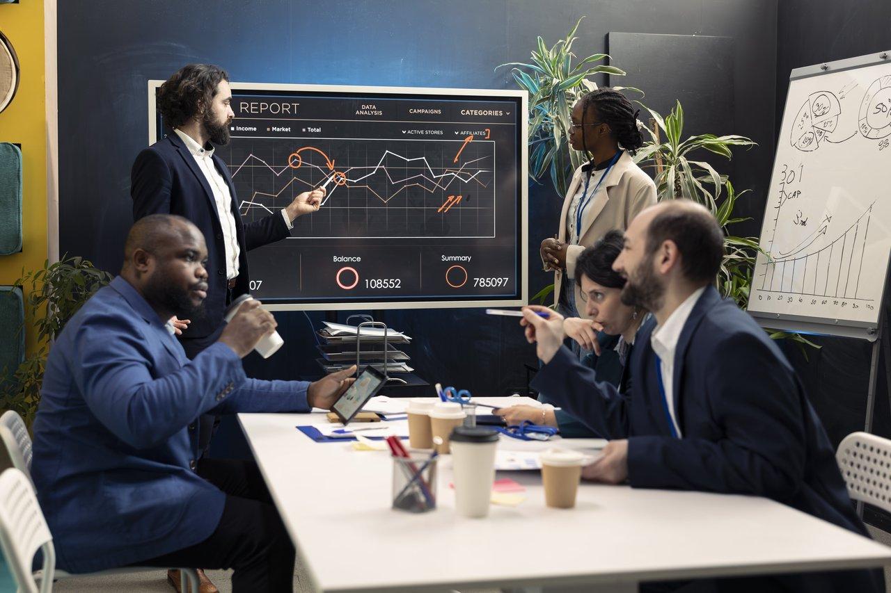 Une équipe technique en réunion autour d’un tableau de bord de performance illustrant l’importance d’une architecture technologique adaptée pour scaler sa startup.