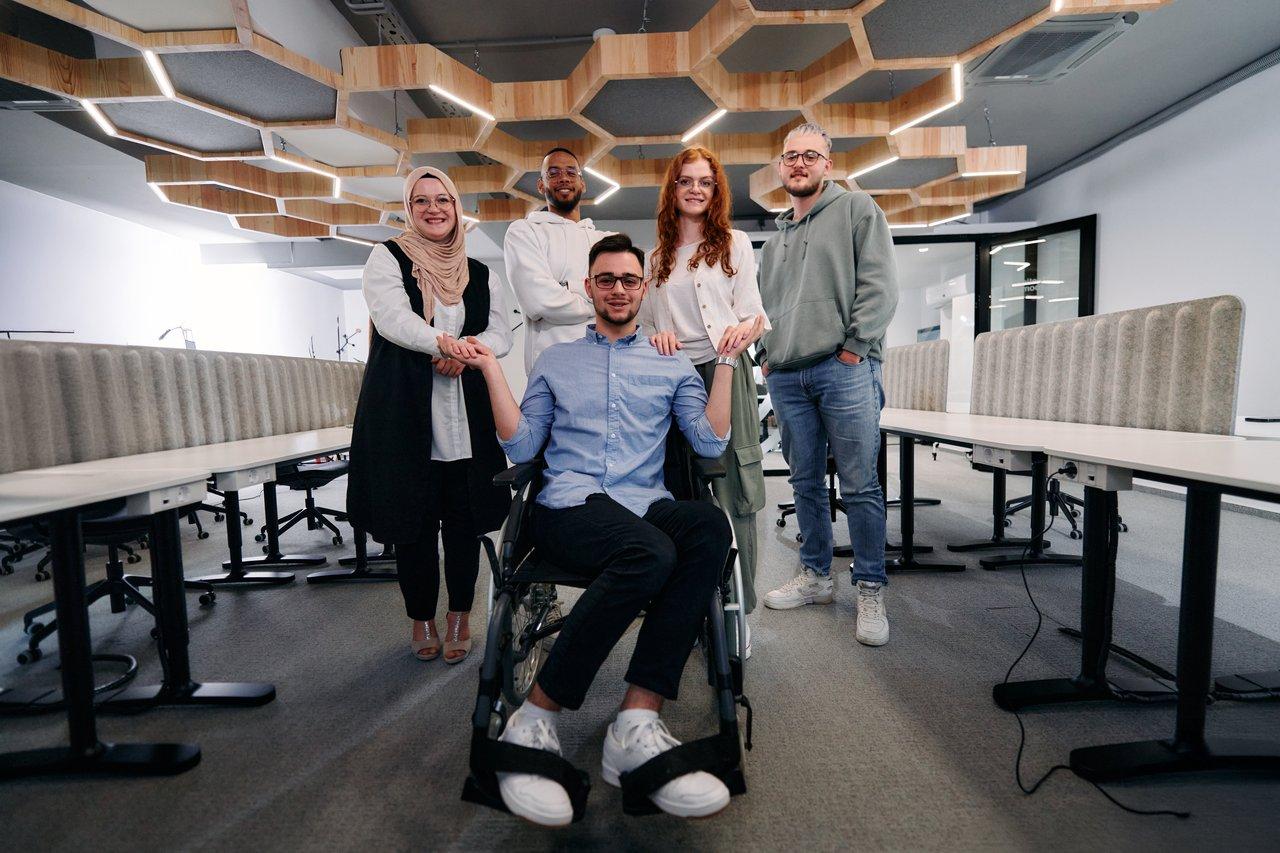 Une jeune équipe innovante favorisant l'inclusion et la collaboration dans un espace de travail lumineux.