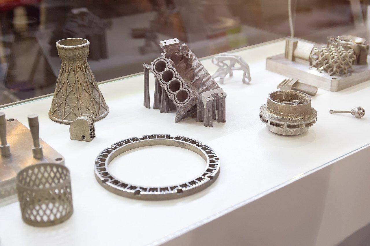 Une ligne de fabrication additive métal (metal additive manufacturing line) avec impression 3D, zones de post-traitement et contrôle automatisé.