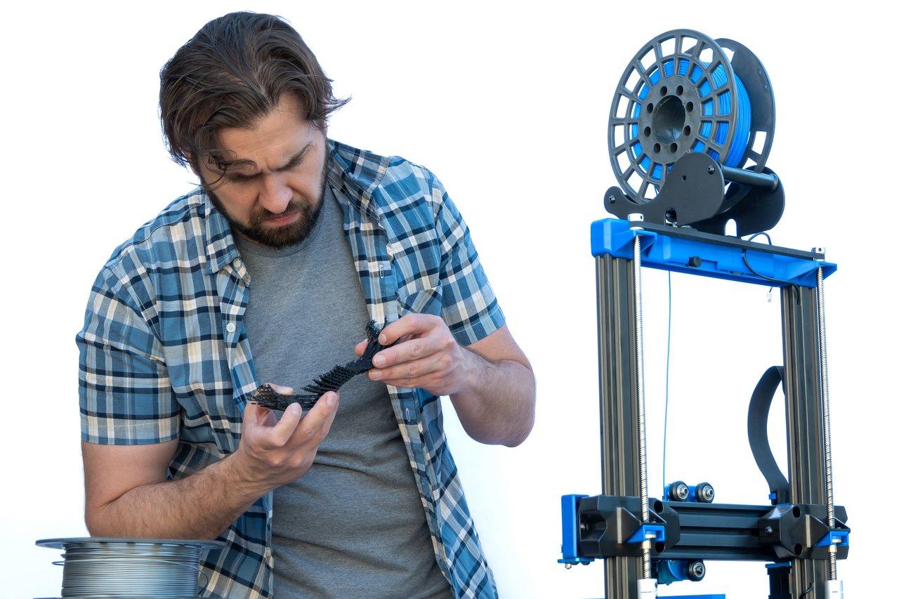 Une startup hardware examine des prototypes en cours d’impression 3D FDM ABS pour optimiser leur développement.